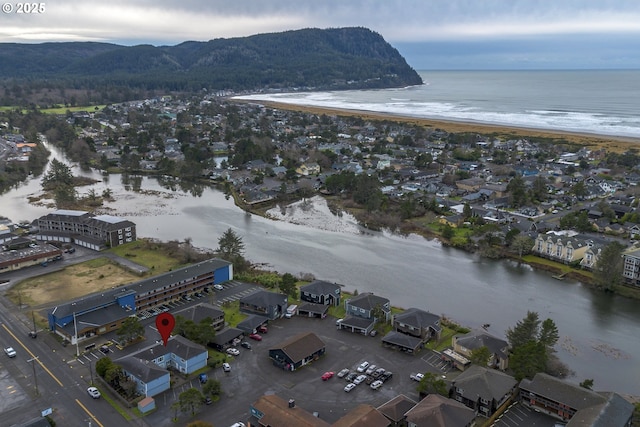 drone / aerial view featuring a water view and a view of the beach