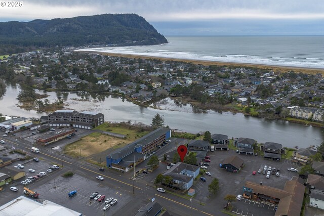 birds eye view of property featuring a water view and a beach view