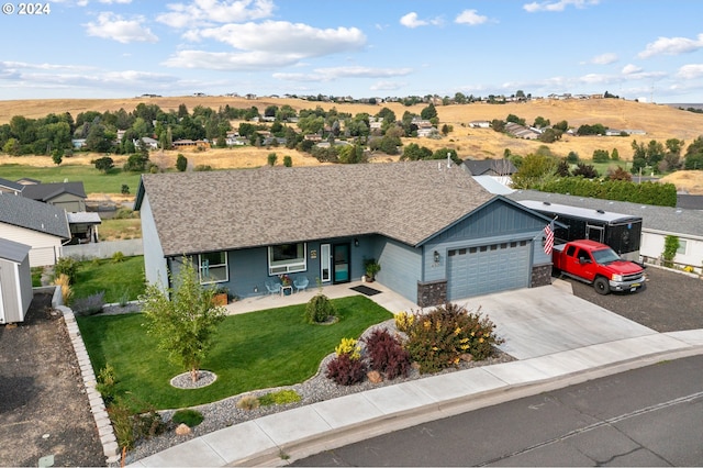 ranch-style house with a garage, a front lawn, and a rural view