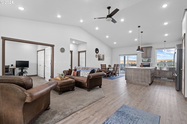 living room featuring lofted ceiling, light hardwood / wood-style flooring, and ceiling fan