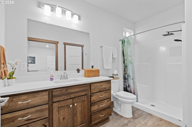 bathroom with curtained shower, hardwood / wood-style floors, toilet, and vanity