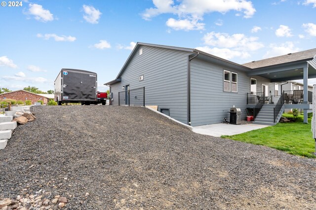 view of side of home featuring a yard and a deck