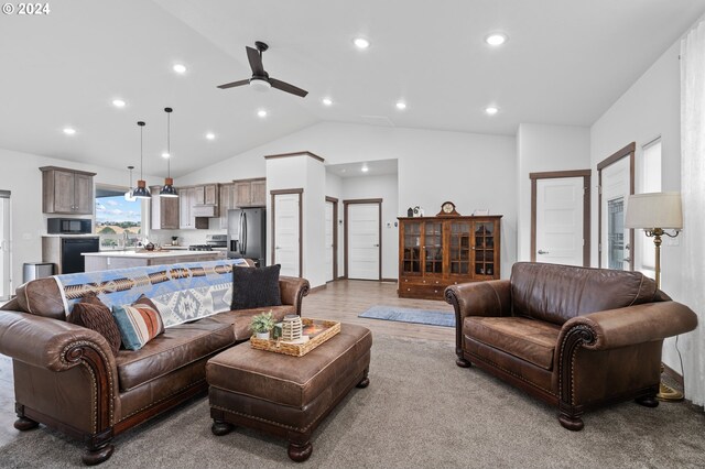 living room featuring lofted ceiling, ceiling fan, and light carpet