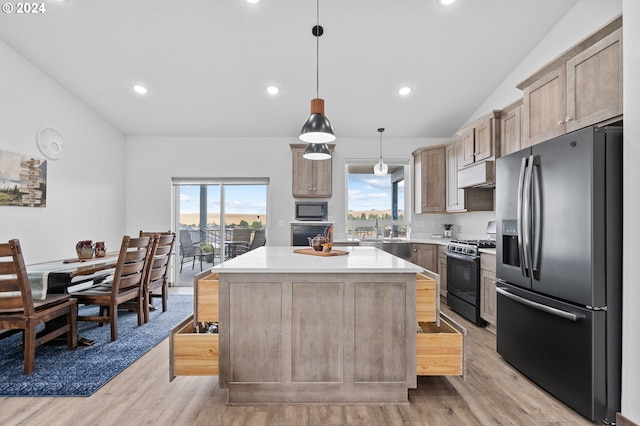 kitchen featuring a wealth of natural light, gas range, black microwave, and stainless steel refrigerator with ice dispenser