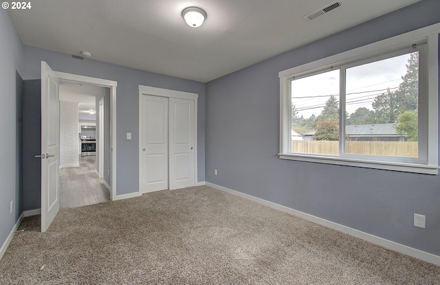 unfurnished bedroom with carpet floors and a closet