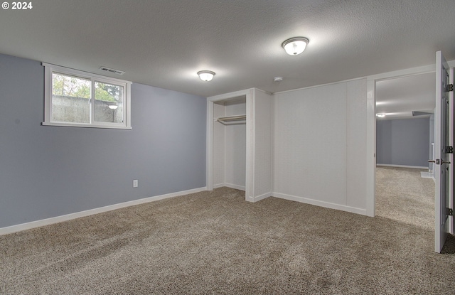 basement featuring a textured ceiling and carpet floors