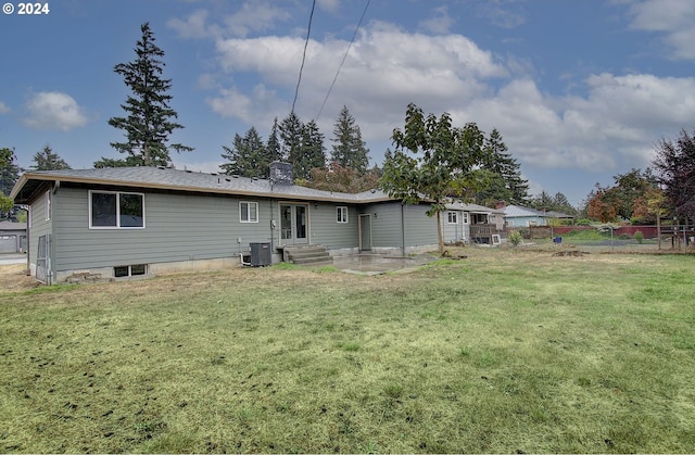 back of property with a lawn and a patio