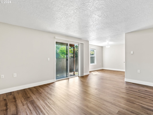 unfurnished room with a textured ceiling and wood-type flooring