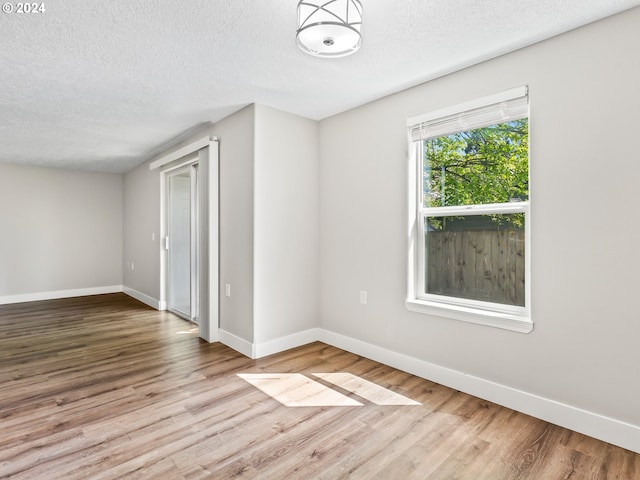 unfurnished room featuring hardwood / wood-style floors and a textured ceiling