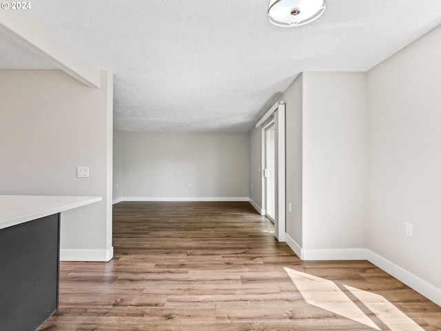 empty room with a textured ceiling and hardwood / wood-style floors