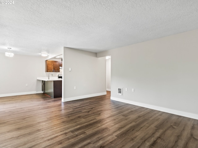 unfurnished living room with dark hardwood / wood-style floors, a textured ceiling, and sink