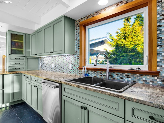 kitchen featuring backsplash, light stone counters, sink, dishwasher, and green cabinets