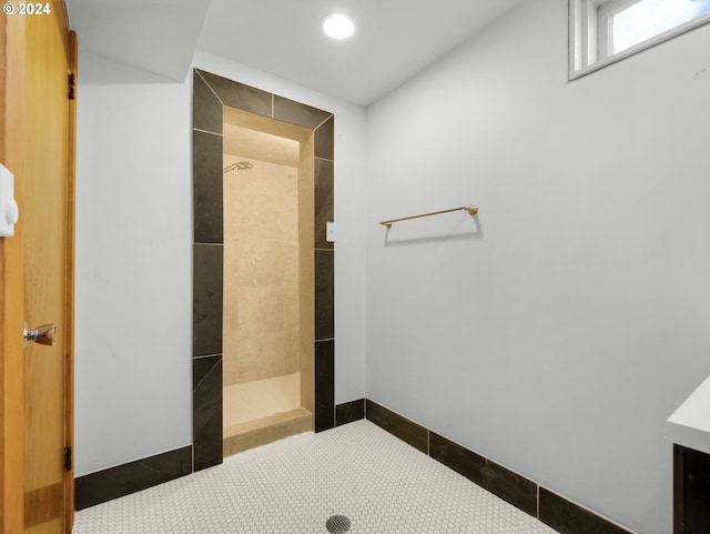 bathroom with tile patterned flooring and a tile shower