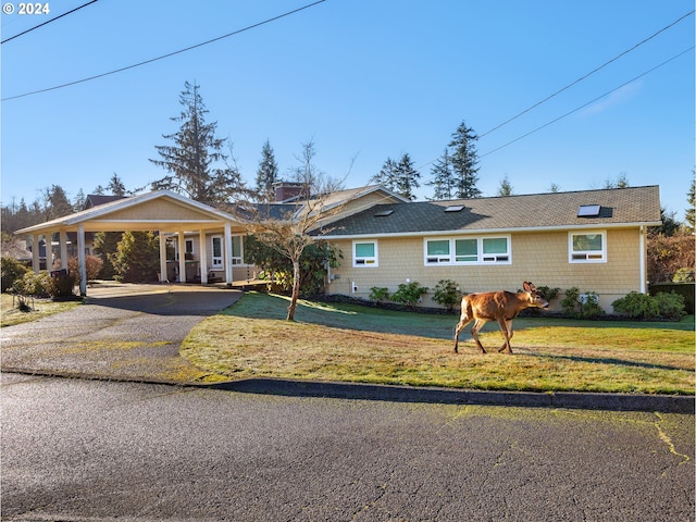 ranch-style home featuring a front yard and a carport