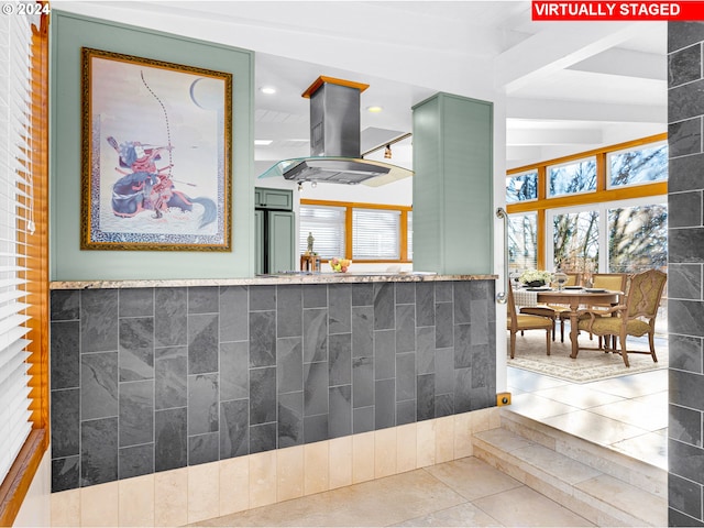 kitchen with tile patterned floors, island range hood, and tile walls