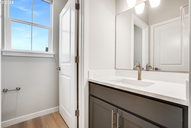 bathroom with vanity, baseboards, and wood finished floors