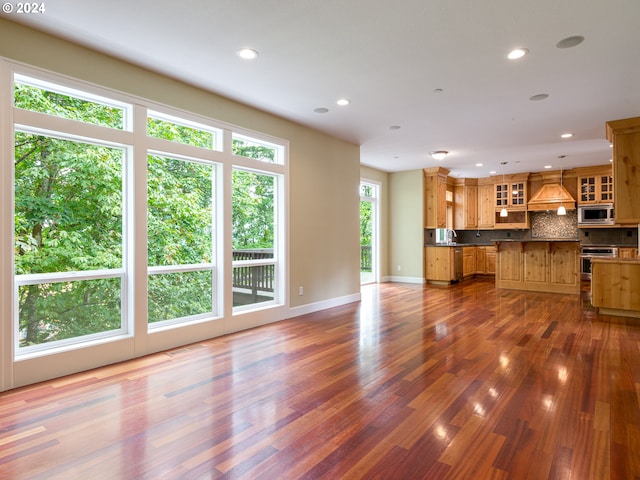 unfurnished living room featuring dark hardwood / wood-style floors and sink