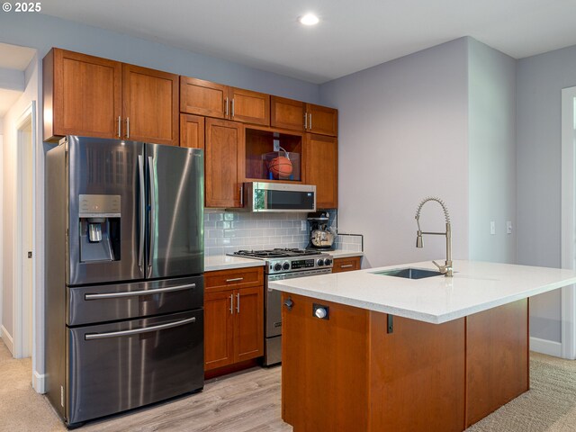 kitchen with a kitchen island with sink, light colored carpet, a healthy amount of sunlight, and stainless steel appliances