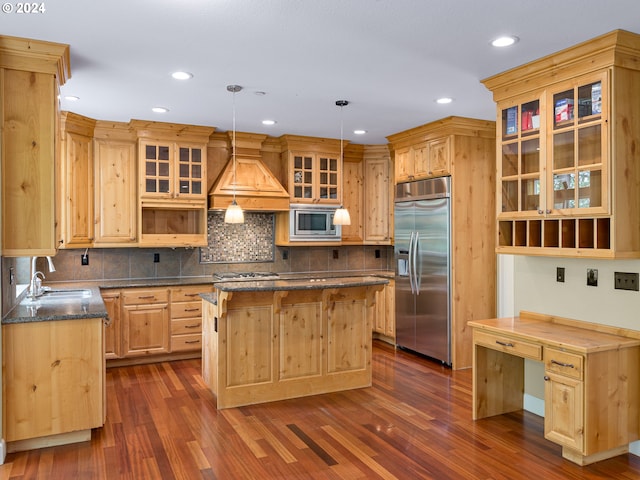 kitchen with dark hardwood / wood-style flooring, hanging light fixtures, built in appliances, and a center island