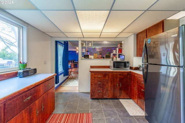 kitchen with stainless steel appliances and a paneled ceiling