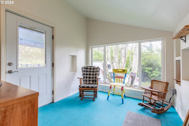 sitting room with vaulted ceiling and carpet flooring