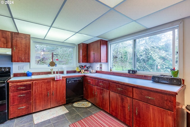 kitchen featuring black appliances, a paneled ceiling, and plenty of natural light