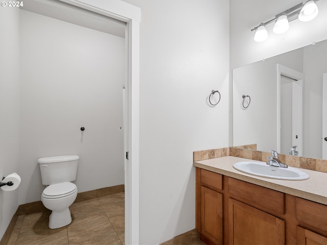 bathroom with tile flooring, vanity, and toilet