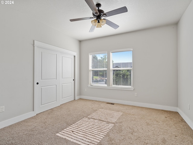 unfurnished room featuring ceiling fan and light carpet