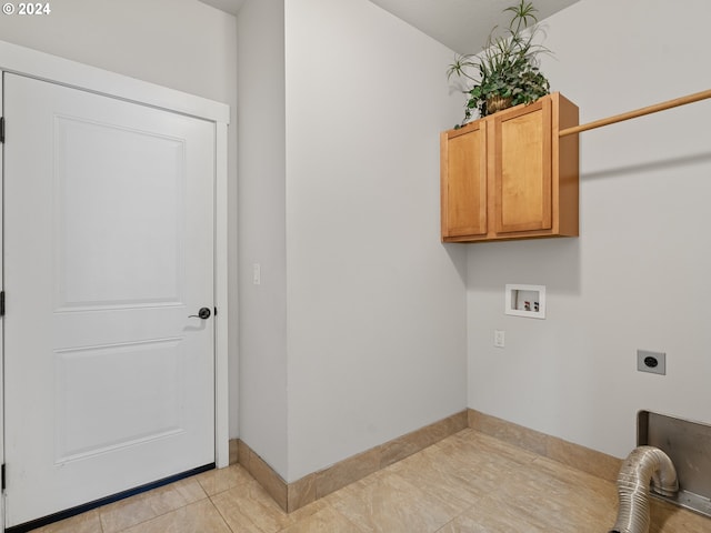 laundry room with hookup for an electric dryer, cabinets, light tile floors, and washer hookup