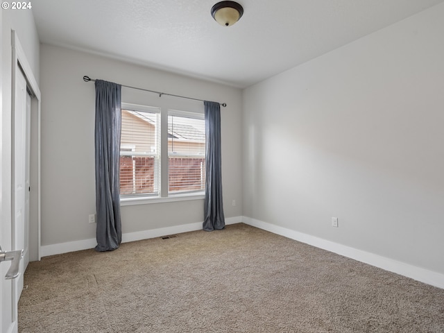 spare room featuring light carpet