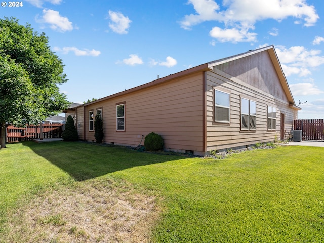 view of home's exterior with a yard and central AC unit