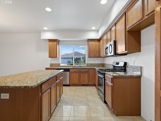 kitchen with sink, dark stone countertops, light tile floors, and stainless steel appliances