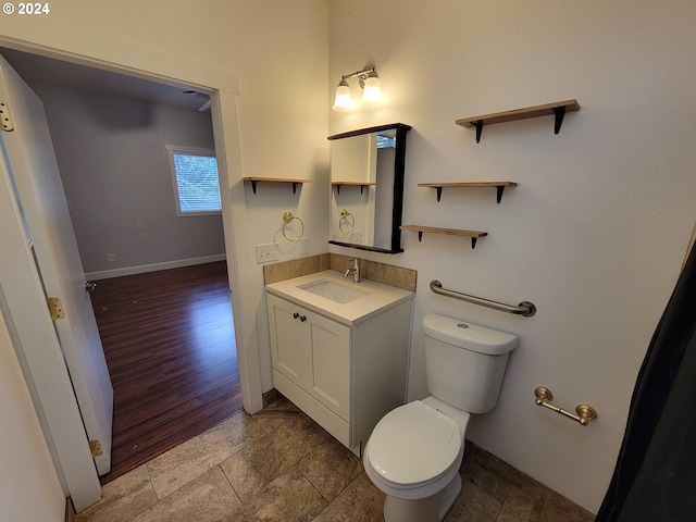 bathroom with vanity, toilet, and wood-type flooring