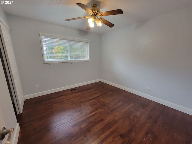 unfurnished room with dark wood-type flooring and ceiling fan