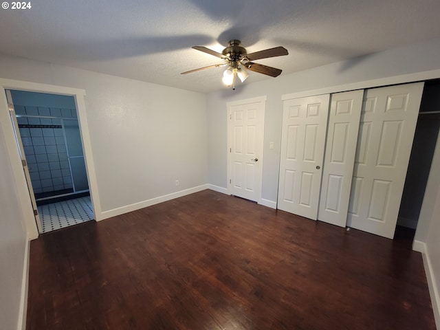 unfurnished bedroom featuring connected bathroom, a textured ceiling, dark hardwood / wood-style floors, and ceiling fan