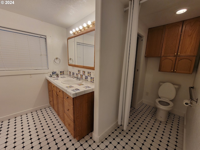 bathroom featuring toilet, vanity, and tile patterned flooring