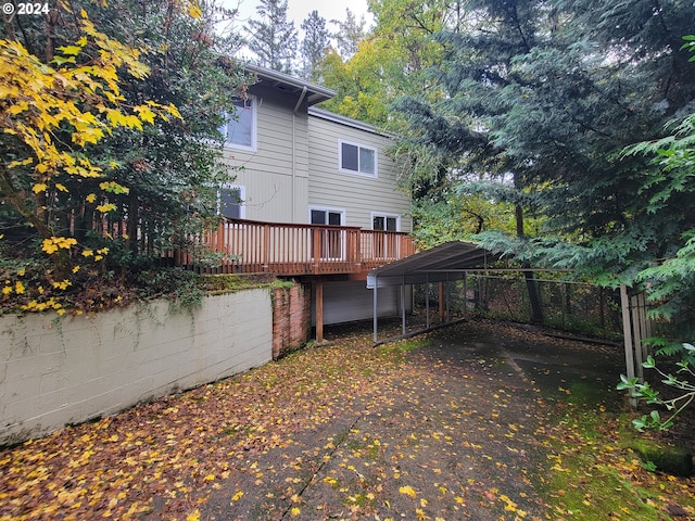 rear view of property with a deck and a carport