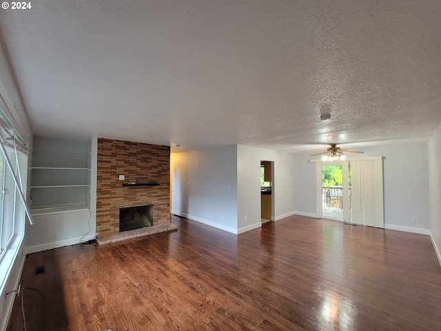 unfurnished living room featuring ceiling fan, dark hardwood / wood-style flooring, a textured ceiling, built in features, and a fireplace