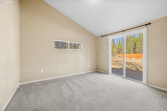 carpeted spare room featuring high vaulted ceiling