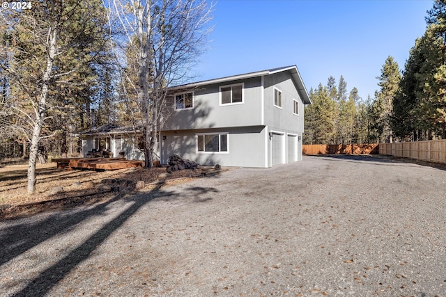 back of house featuring a garage and a deck