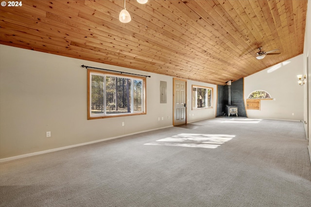 unfurnished living room featuring wood ceiling, a wood stove, vaulted ceiling, carpet floors, and ceiling fan