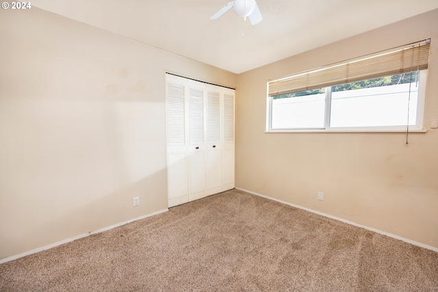 unfurnished bedroom featuring carpet floors, a closet, and ceiling fan