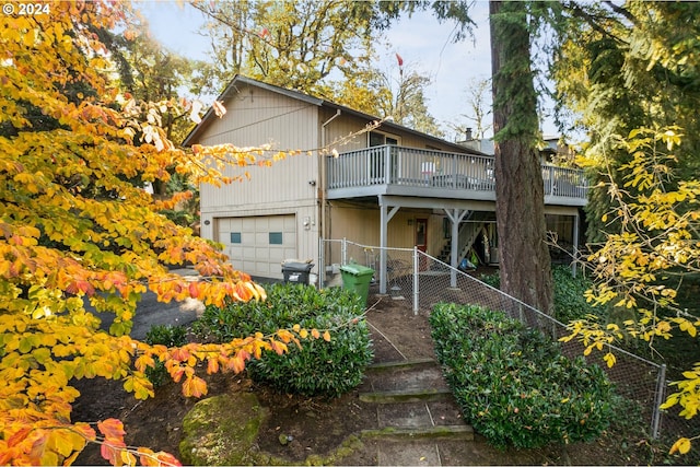 front of property featuring a garage and a wooden deck