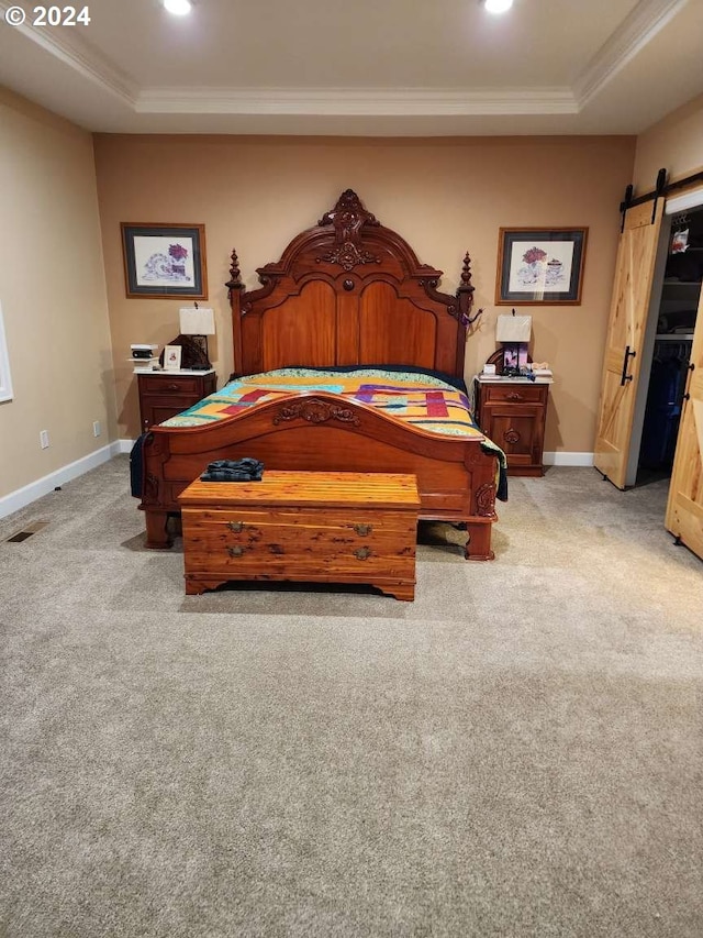 bedroom featuring a barn door, a raised ceiling, and light colored carpet