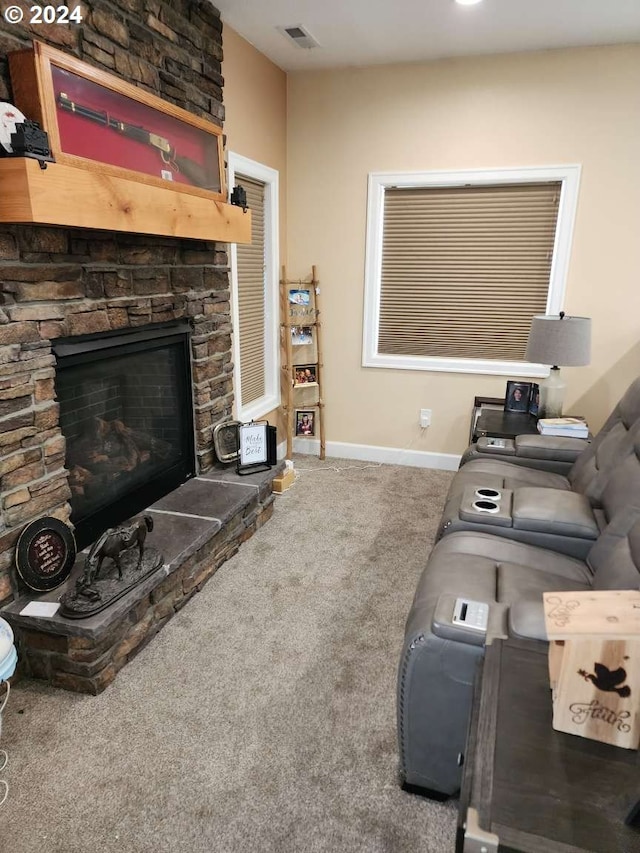 living room featuring carpet and a stone fireplace