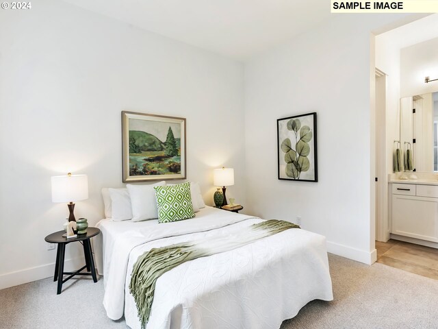 bedroom with light colored carpet and ensuite bathroom