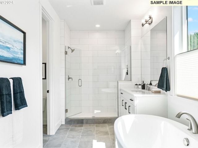 bathroom featuring vanity with extensive cabinet space, tile flooring, and independent shower and bath