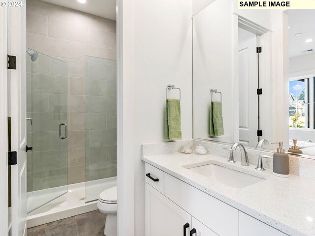 bathroom with an enclosed shower, vanity, tile floors, and toilet