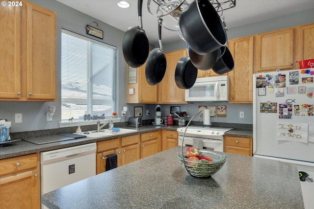 kitchen with light brown cabinetry, white appliances, and sink