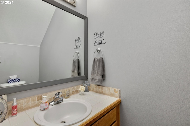 bathroom featuring large vanity and lofted ceiling